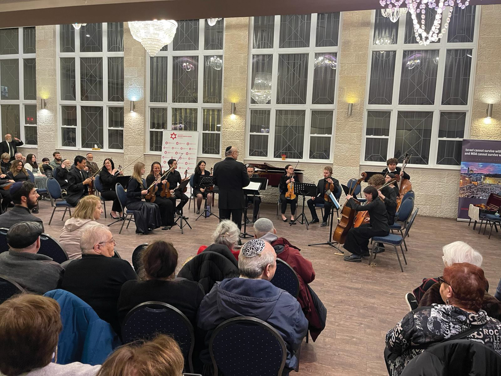 Orchestra performing for the audience in the community hall