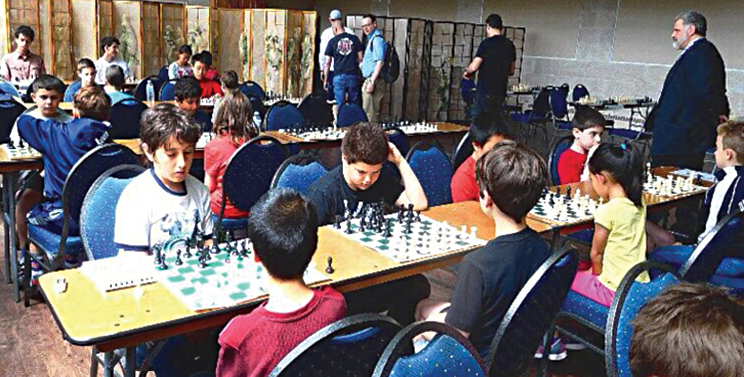 Children playing chess at the community chess tournament