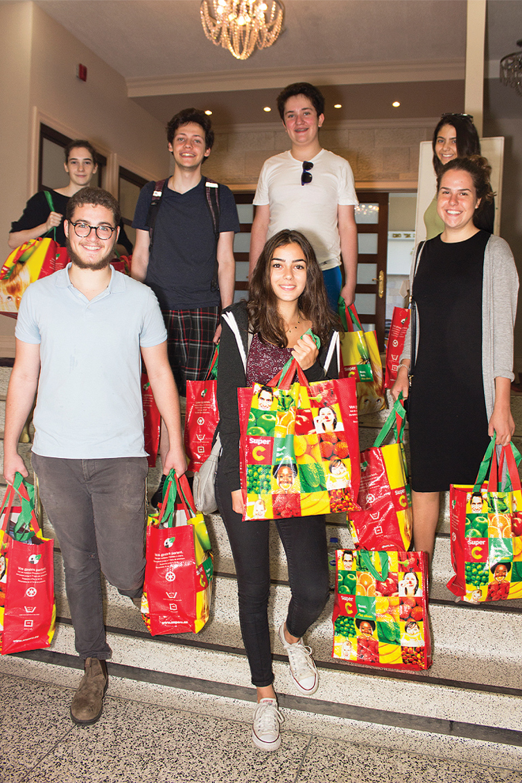 CTeen youth volunteers holding bags of food charity distribution