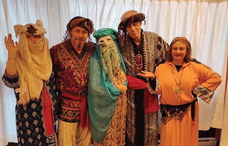 Adults posing in traditional Purim outfits